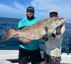 Two men holding a grouper on a Key West fishing charter