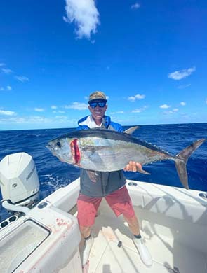 man on a boat holding a fish