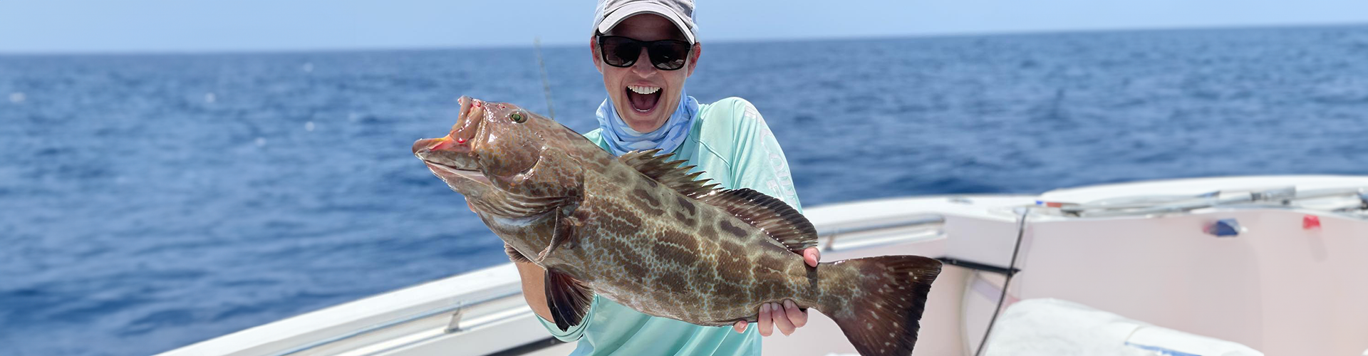 Woman catching grouper on a Key West offshore fishing charter